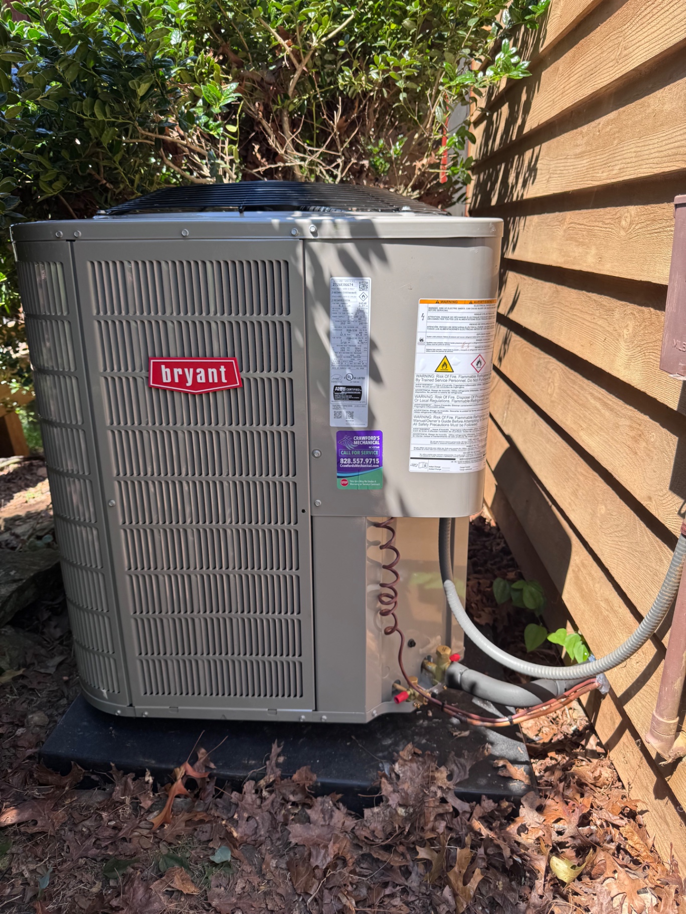 Bryant outdoor HVAC unit installed beside a wood-sided home